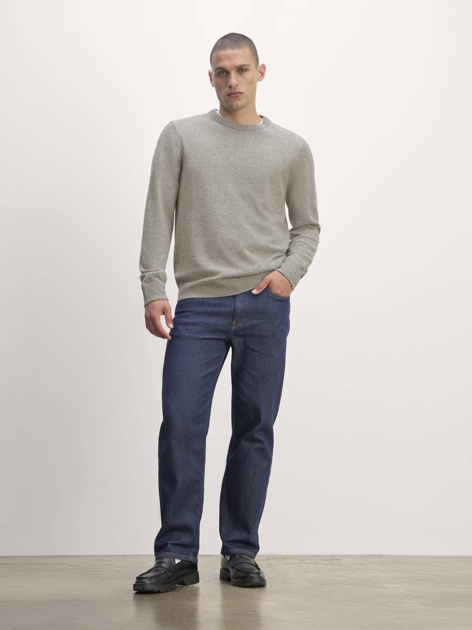 A model wearing a grey cashmere sweater from Everlane.