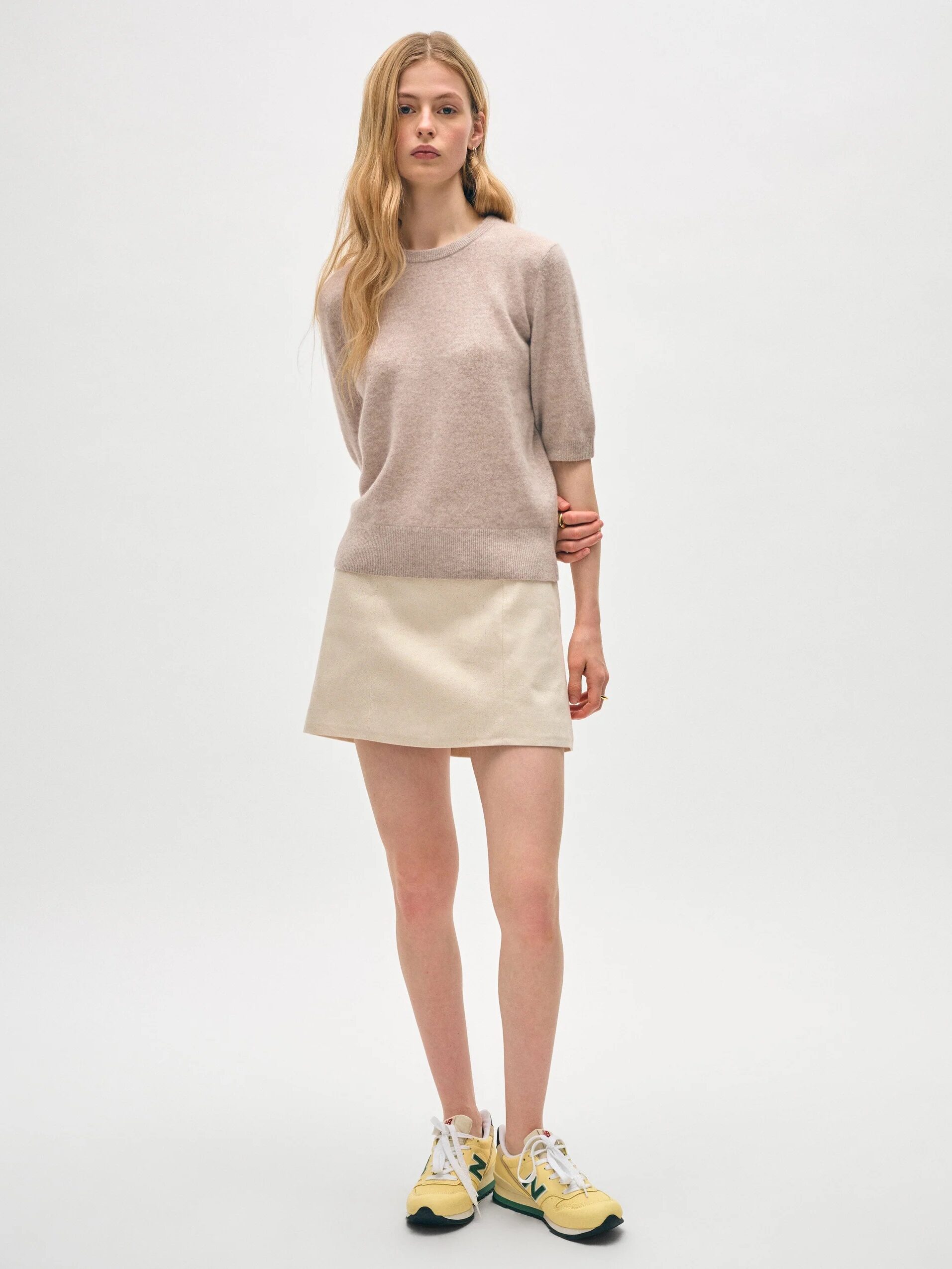 A model wearing a beige 3/4 sleeve length cashmere sweater from White & Warren.